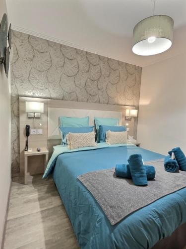 a bedroom with a large blue bed with blue pillows at Les Platanes in Gorrevod