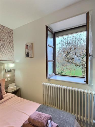 a bedroom with a bed and a window at Les Platanes in Gorrevod