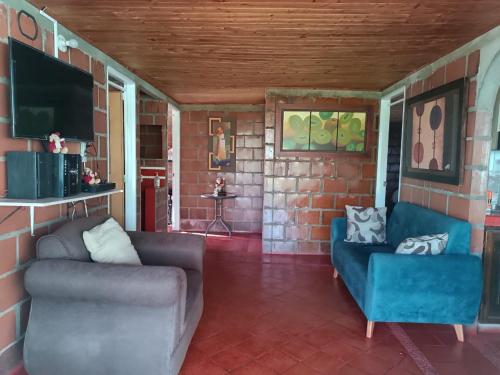 a living room with two chairs and a tv at Alojamiento Campestre San Carlos in Montenegro
