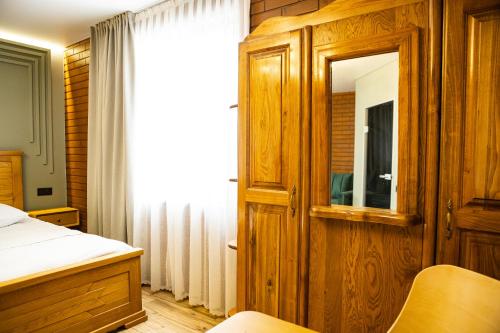 a bedroom with a bed and a mirror at Zatyshok nad Prutom in Bukovel