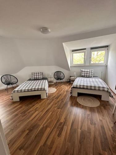 um quarto com 2 camas e piso em madeira em Großzügige Wohnung im Zentrum em Paderborn