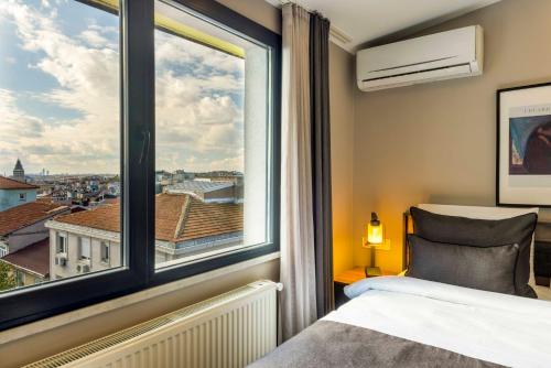 a bedroom with a window with a view of a city at APARTMENTS BAKRAC 26 in Istanbul