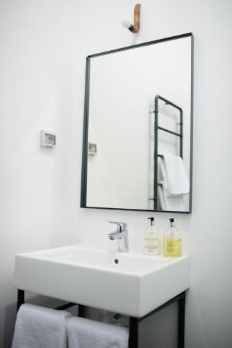 a bathroom with a white sink and a large mirror at Ceglarnia in Książ Wielkopolski