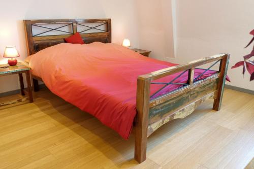 a large bed with an orange comforter in a bedroom at Goldener Löwe in Bodman-Ludwigshafen
