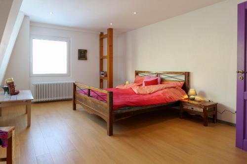 a bedroom with a bed with red sheets and a window at Goldener Löwe in Bodman-Ludwigshafen