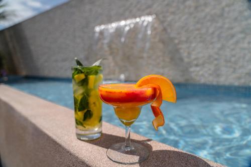 a drink with an orange slice in a glass next to a pool at Jose Antonio Deluxe in Lima