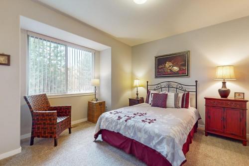 a bedroom with a bed and a chair and a window at Eagle Crest Family Retreat in Redmond