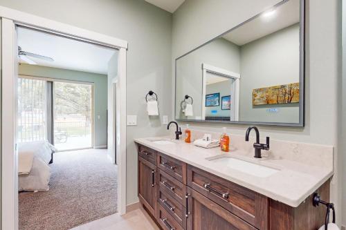 ein Badezimmer mit einem Waschbecken und einem großen Spiegel in der Unterkunft Eagle Crest Family Retreat in Redmond