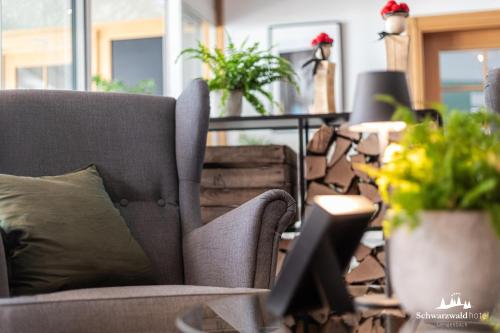 a living room with a couch and potted plants at Schwarzwaldhotel Gengenbach in Gengenbach