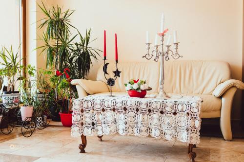 a living room with a couch with a table with two candles at Pensiunea Colt de Rai Cean 
