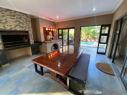 a living room with a wooden table and a fireplace at Blissful Bracelet in Nelspruit