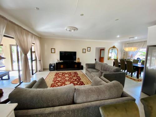 a large living room with couches and a television at Blissful Bracelet in Nelspruit