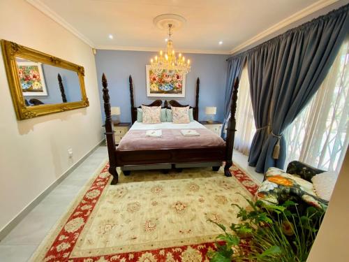 a bedroom with a bed and a chandelier at Blissful Bracelet in Nelspruit