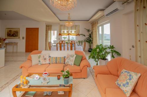 ein Wohnzimmer mit zwei orangenen Sofas und einem Tisch in der Unterkunft Apple home Detached house in sunny Ierapetra in Ierápetra