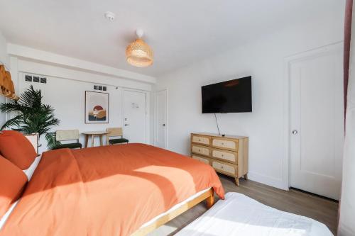 a bedroom with a bed and a flat screen tv at Tropics Hotel Miami Beach in Miami Beach