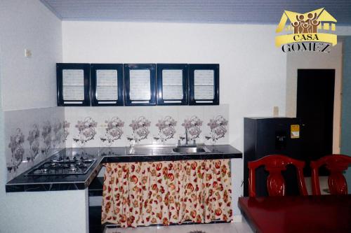 a kitchen with a sink and a stove with wine glasses at Casa Gomez Apto 2 in Leticia