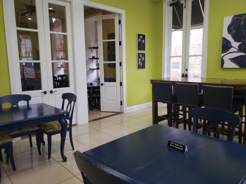 una sala da pranzo con tavoli e sedie e pareti verdi di Natchez Manor Bed & Breakfast a Natchez