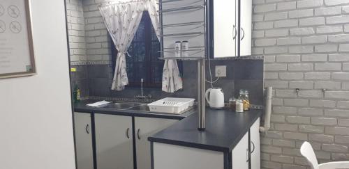eine Küche mit einer schwarzen Theke und einem Waschbecken in der Unterkunft Happy Haven in Welkom