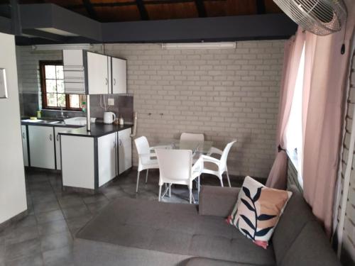 a kitchen with a table and white chairs in a room at Happy Haven in Welkom