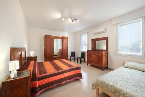 a bedroom with two beds and a dresser and a desk at Casa Cicolani in Scardovari