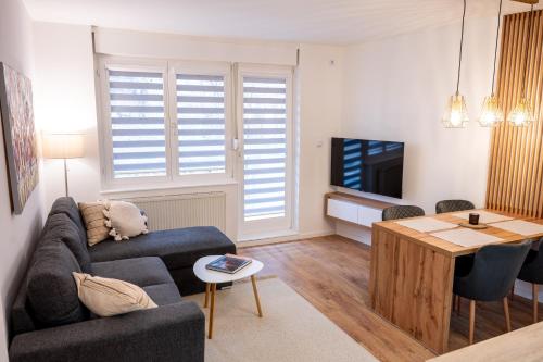 a living room with a couch and a table at Poppy Elegance City Center & Free parking in Sarajevo
