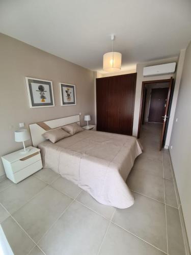 a bedroom with a large bed and two lamps at Lightoasis Oasis Mar 3 in Portimão