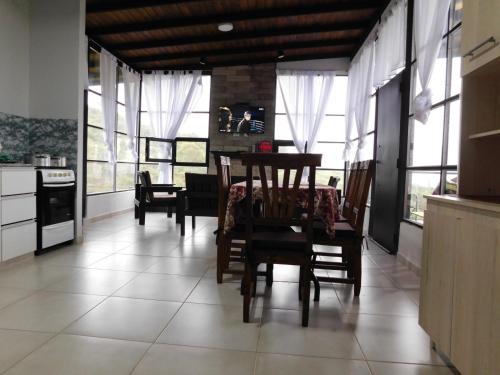 d'une cuisine avec une table, des chaises et des fenêtres. dans l'établissement Utopía - Cabaña de Montaña, à Las Juntas