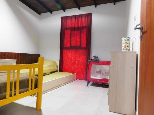 1 dormitorio con cama y cortina roja en Utopía - Cabaña de Montaña en Las Juntas