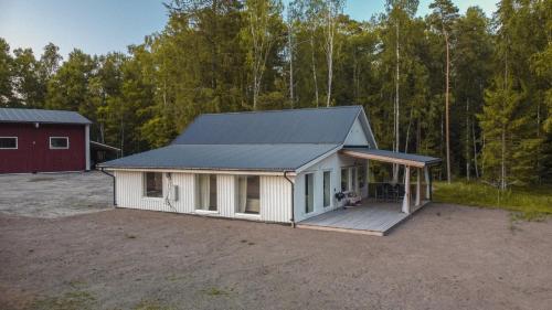 Cette petite maison blanche dispose d'une terrasse couverte. dans l'établissement Villa intill naturreservat, à Ryssby