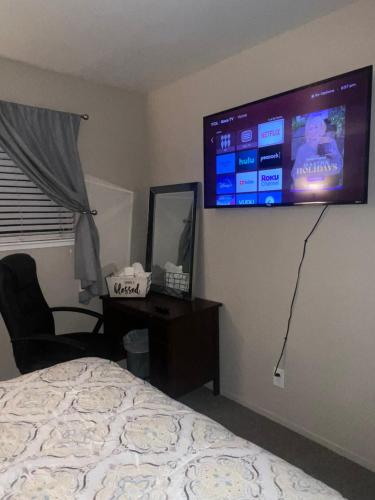 a bedroom with a bed and a television on the wall at Wonderful Private Queen Bedroom in Santa Clara