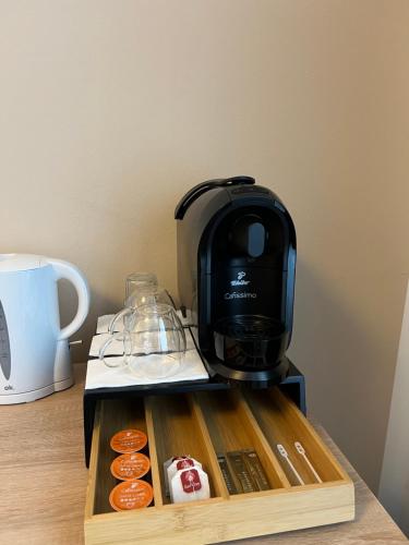 uma máquina de café sentada em cima de uma mesa com donuts em Avento Hotel Hannover em Hanôver