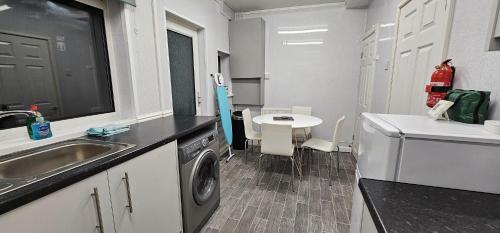 una cucina con lavandino e lavatrice di 8 Suffolk street by Prestige Properties SA a Roose