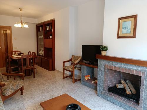 a living room with a fireplace and a tv at Muralla in Camprodon