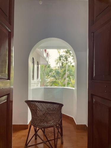 a room with a chair and an archway at RiTAS in Varkala