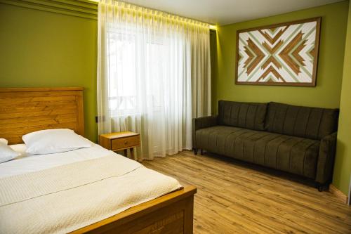 a bedroom with a bed and a couch at Zatyshok nad Prutom in Bukovel