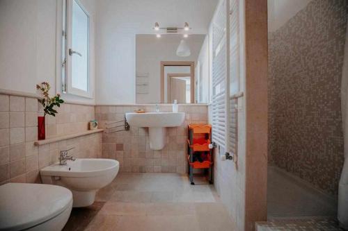 un bagno con lavandino, WC e specchio di Tenuta Matilda by TripOstuni a Ostuni