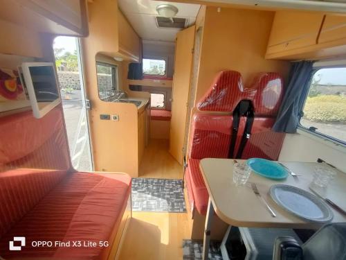 ein Zimmer mit einem Tisch und Stühlen in einem Zug in der Unterkunft Autocarabana Ford trigano in Arrecife