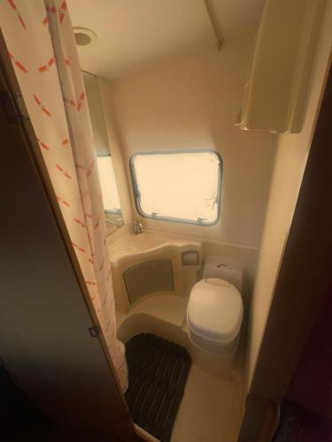 a small bathroom with a toilet and a window at Autocarabana Ford trigano in Arrecife