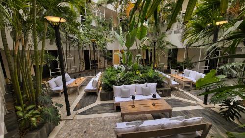 un restaurante con mesas, sillas y palmeras en THE HOTEL en Córdoba