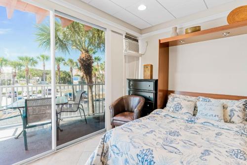a bedroom with a bed and a balcony with a table at Sunrise haven in Clearwater Beach