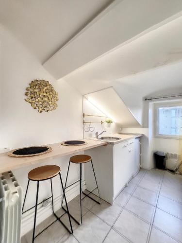 - une cuisine avec deux tabourets de bar et un évier dans l'établissement Au Bel Ami, à Nantes