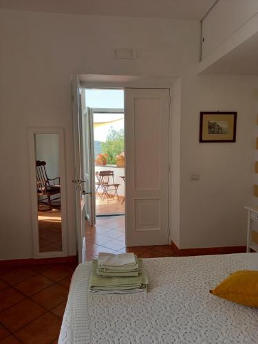 ヴィーコ・エクエンセにあるLa Casa Del Soleのベッドルーム1室(ベッド1台付)、パティオへ続くドアが備わります。