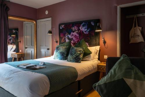 a bedroom with a king sized bed with purple walls at The Archangel,Restaurant & Bar with Rooms in Frome