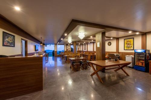 a restaurant with tables and chairs and a bar at Ekant Retreat Resort in Chail