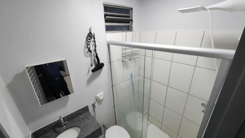 a bathroom with a toilet and a glass shower at Quitinete Ar Condicionado WIFI Garagem Individual in Goiânia
