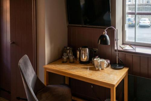 a small wooden table with a lamp on top of it at The Archangel,Restaurant & Bar with Rooms in Frome