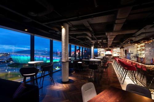 a bar with chairs and tables and a view of the city at Glasgow, Finnieston Luxury 2 Bed with parking, e-check in, hi-fi in Glasgow