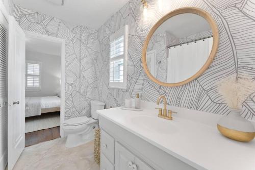 a bathroom with a sink and a mirror and a toilet at Redington Beach Bungalow in St. Pete Beach