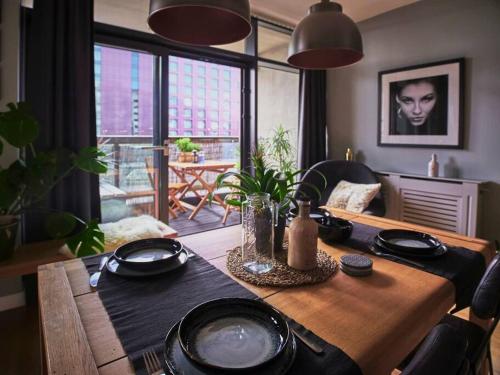 a dining room table with black plates and sidx sidx sidx sidx at Glasgow, Finnieston Luxury 2 Bed with parking, e-check in, hi-fi in Glasgow
