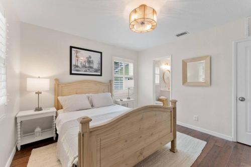 a bedroom with a wooden bed and a lamp at Redington Beach Bungalow in St. Pete Beach
